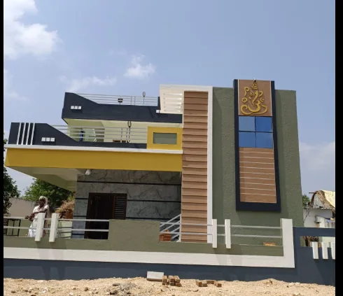 Contemporary house facade with layered bands, a tall brown panel and a Ganesha motif.